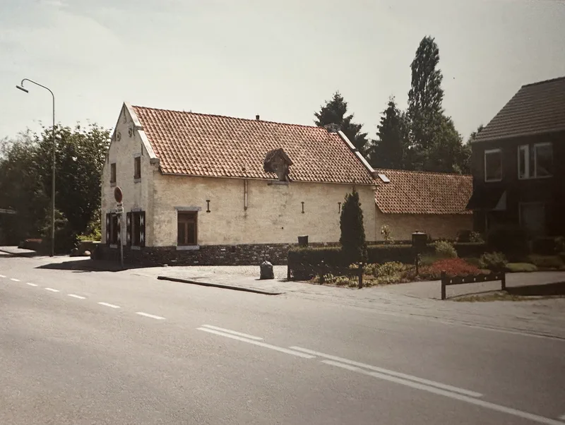 Het huis gezien vanaf de weg naar Valkenburg: de lange zijgevel van blanke mergel met het rode pannendak